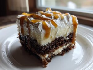 A decadent slice of gingerbread trifle featuring dark cake layers, cream filling, whipped topping, and a rich caramel drizzle.
