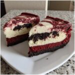Two decadent slices of red velvet cheesecake showing layers of red cake, white cheesecake, and dark chocolate swirl.
