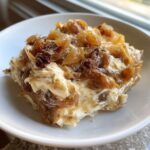 A generous scoop of creamy onion dip topped with deeply caramelized onions served in a white bowl.