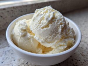 Close-up of creamy white scoops of snow ice cream served in a small white bowl.