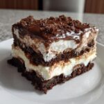 A decadent slice of Baileys Chocolate Cheesecake Trifle showing rich layers of chocolate cake, cream cheese filling, and chocolate topping.