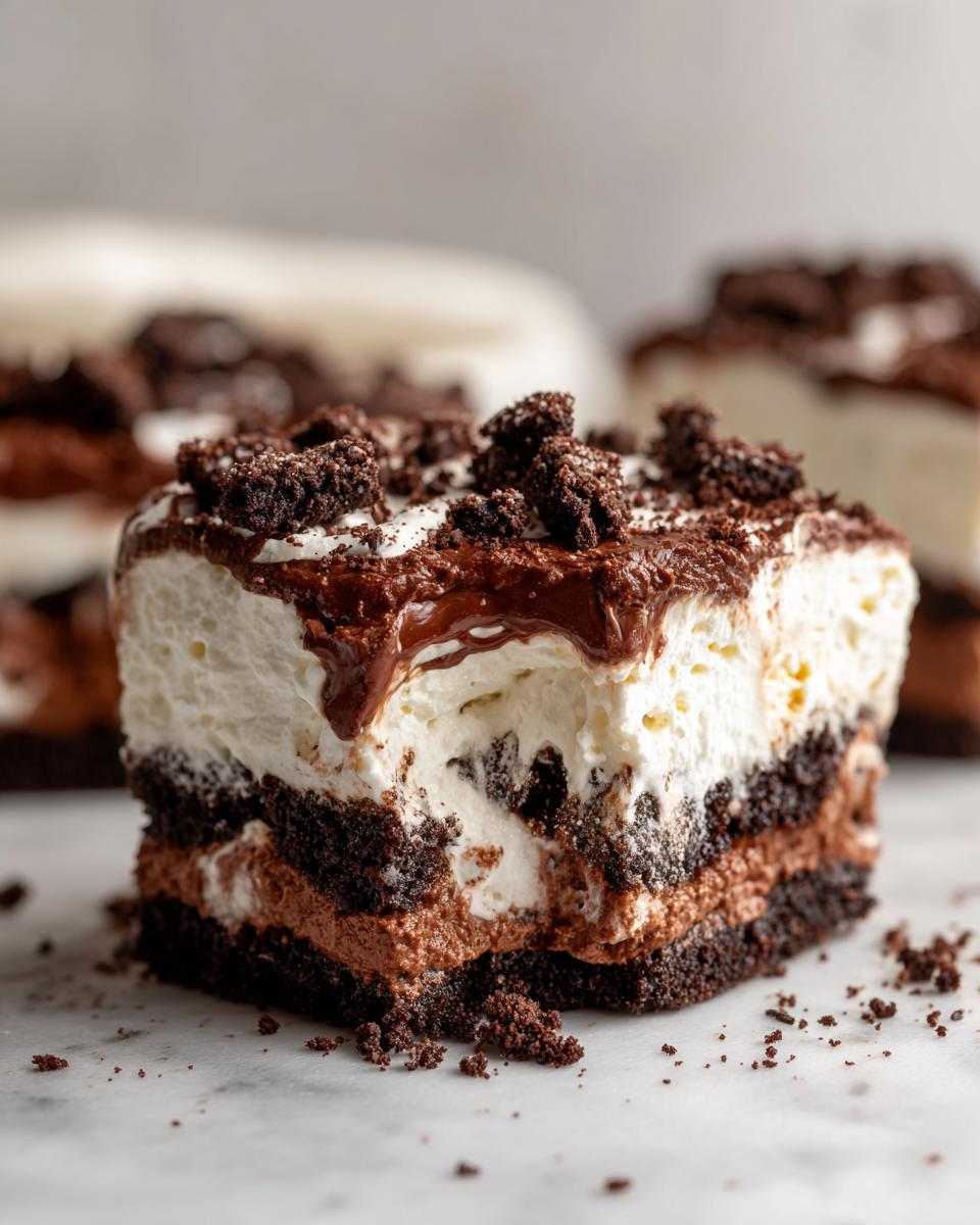 Close-up of a layered slice of Baileys Chocolate Cheesecake Trifle showing dark cake, mousse, and whipped topping.