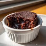 Close-up of a rich, dark chocolate Cottage Cheese Microwave Brownie with a molten center, served in a white ramekin.