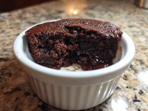 Close-up of a rich, dark chocolate Cottage Cheese Microwave Brownie served warm in a white fluted ramekin.