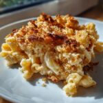 A close-up serving of creamy baked mac and cheese featuring a deeply browned, crunchy breadcrumb topping.