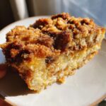 Close-up of a moist slice of overnight french toast casserole topped with a thick, crunchy cinnamon streusel.