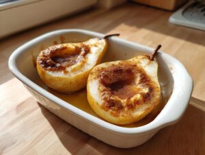 Two halves of baked pears, caramelized with cinnamon sugar, sitting in a white dish.