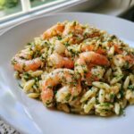 Close-up of a serving of amazing shrimp orzo salad, featuring plump pink shrimp tossed with herbs and orzo pasta.