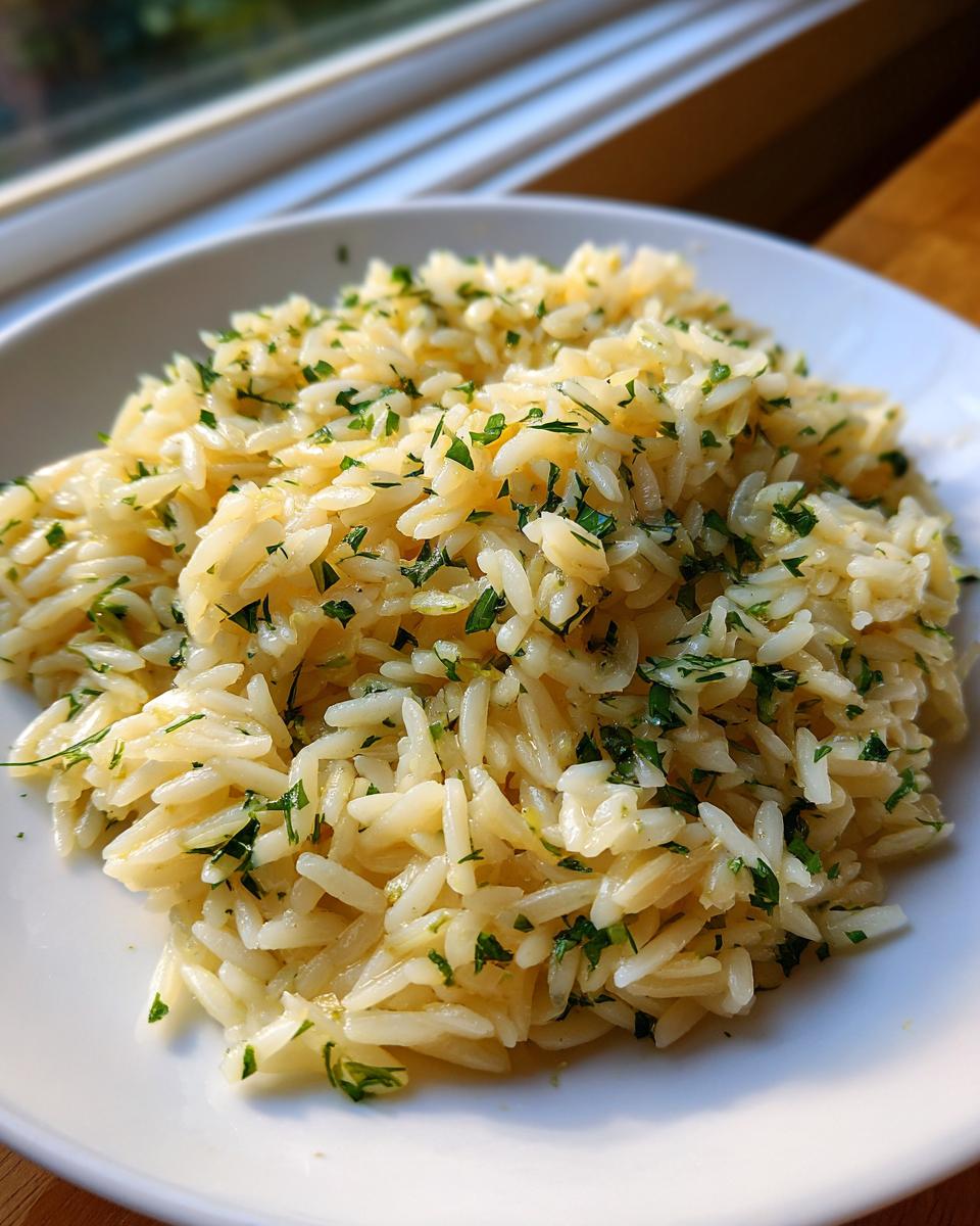 Close-up of fluffy, seasoned greek rice garnished generously with chopped fresh parsley on a white plate.