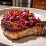 A perfectly seared pork chop topped with vibrant Pork Chops with Ancho Chilli Rhubarb Salsa.