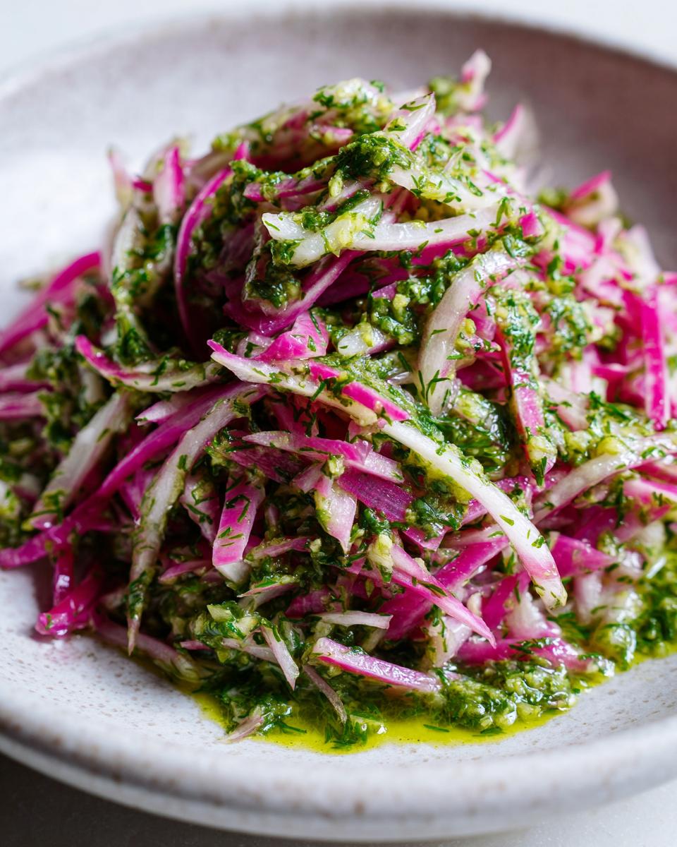 Close-up of vibrant Rhubarb and Fennel Slaw coated in bright green Chimichurri dressing, served in a light bowl.