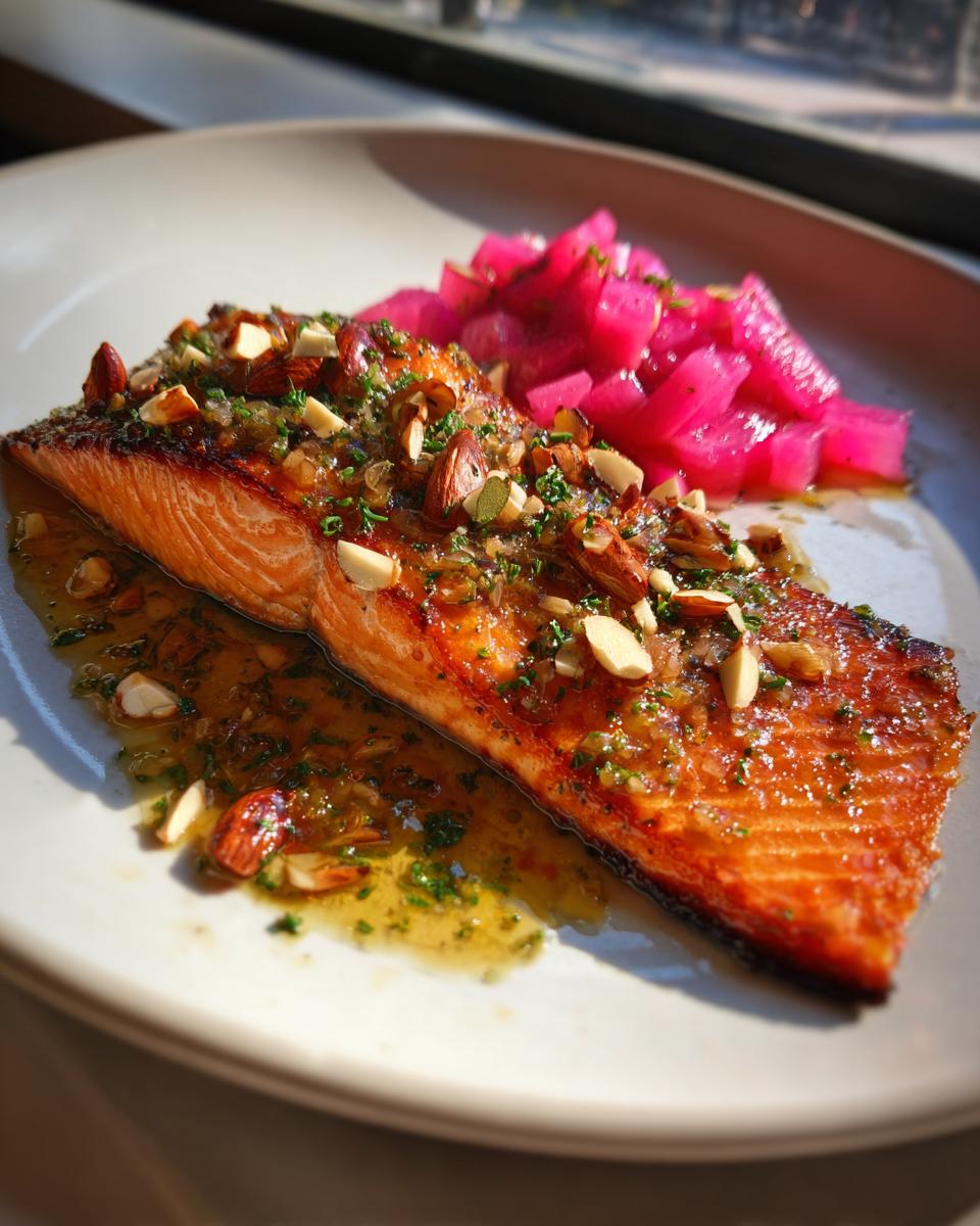 Close-up of a perfectly cooked piece of Smoked Trout with Brown Butter and Rhubarb, topped with sliced almonds.