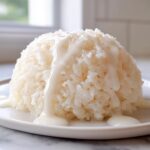 A perfectly molded dome of sticky thai coconut rice drizzled generously with a sweet, creamy coconut sauce.