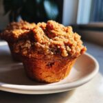 Close-up of a perfectly baked Whole Wheat Rhubarb Streusel Muffin with a thick, crumbly topping.