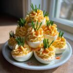 A tiered arrangement resembling a bouquet made from piped deviled eggs, garnished with chives and paprika.